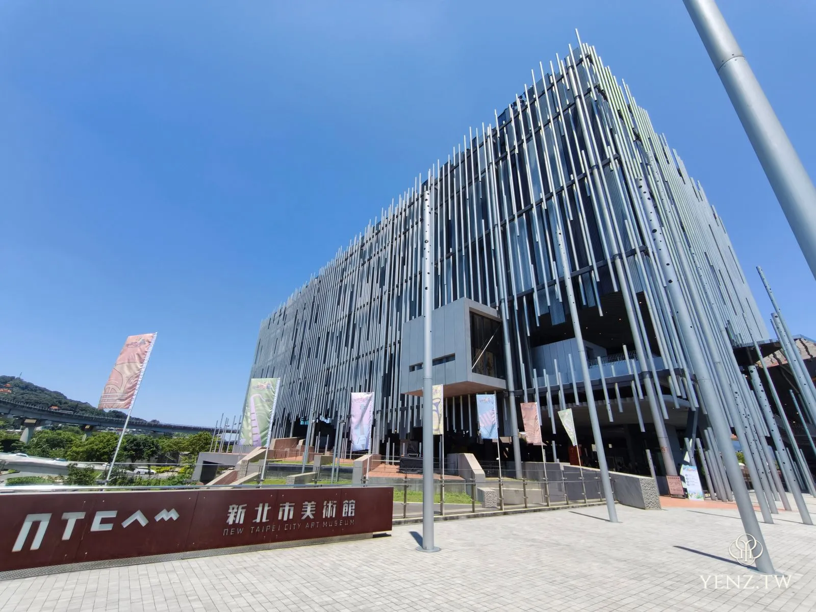 晴空下的新北市美術館，外牆由密集的銀色鋁管組成，像一片直立的蘆葦叢。