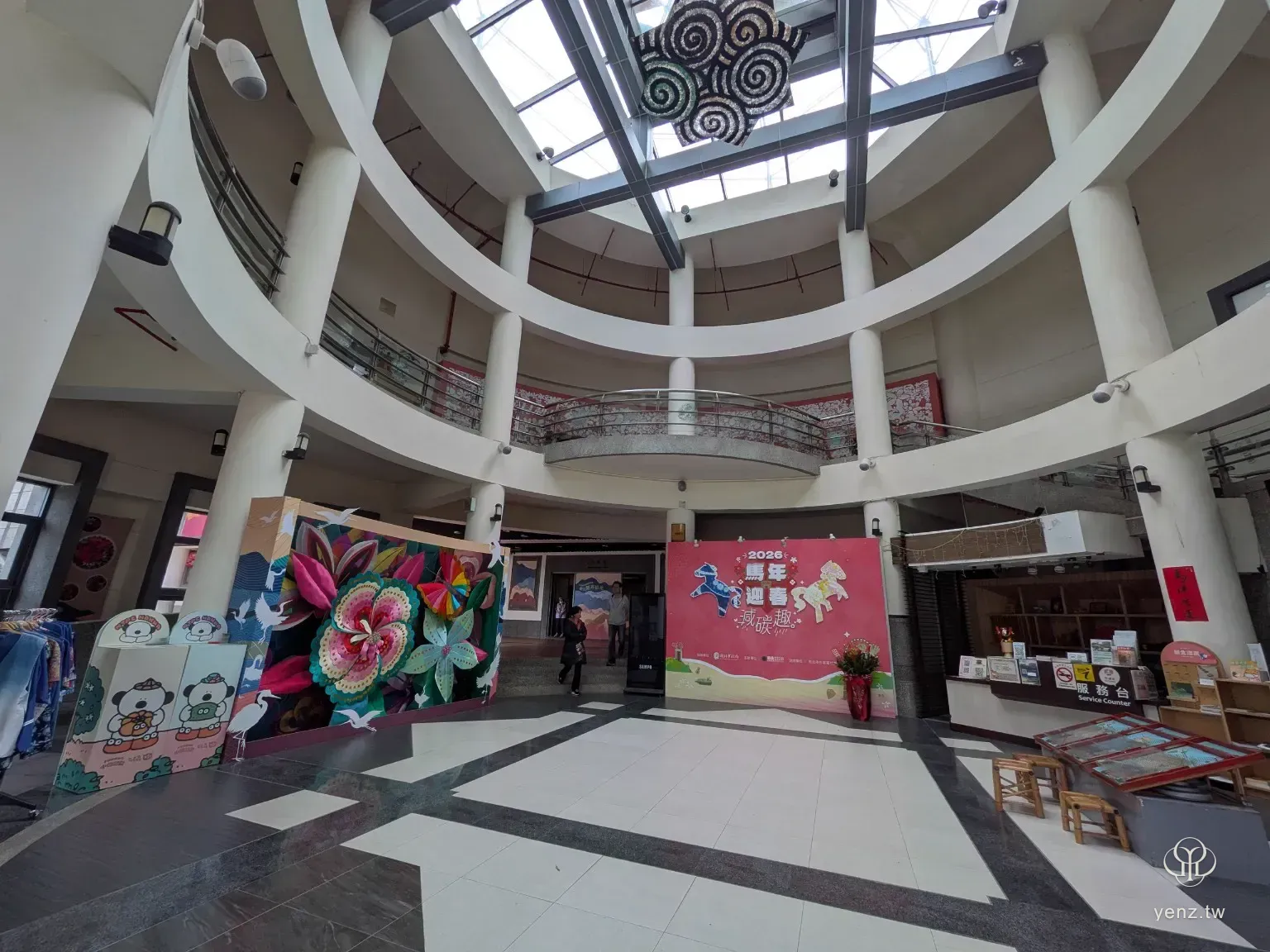 新北市客家文化園區圓形大廳全景，中央有花卉裝置，周圍是環形樓層。