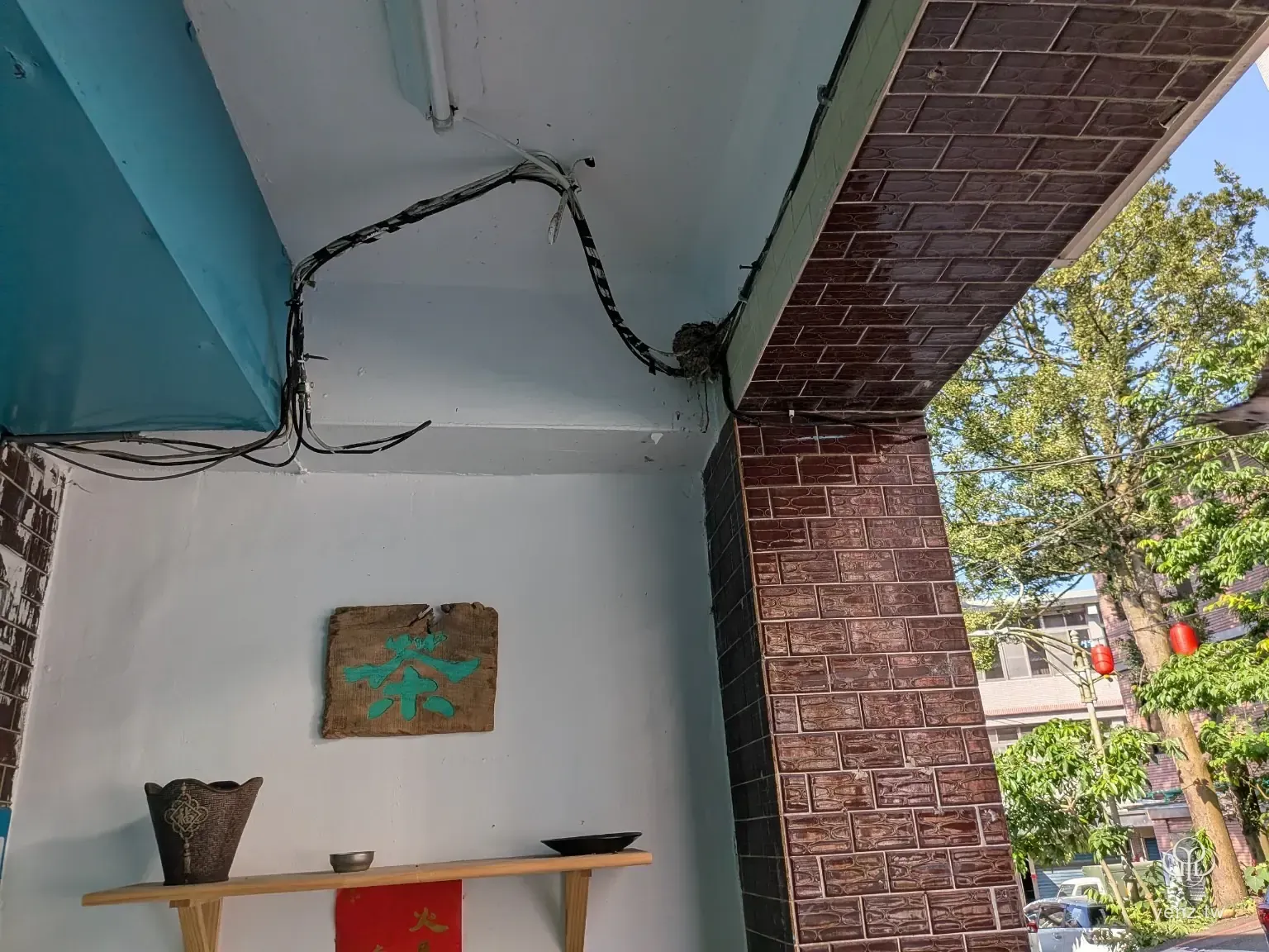茶字招牌上方可見屋簷下的燕巢與街區門面。