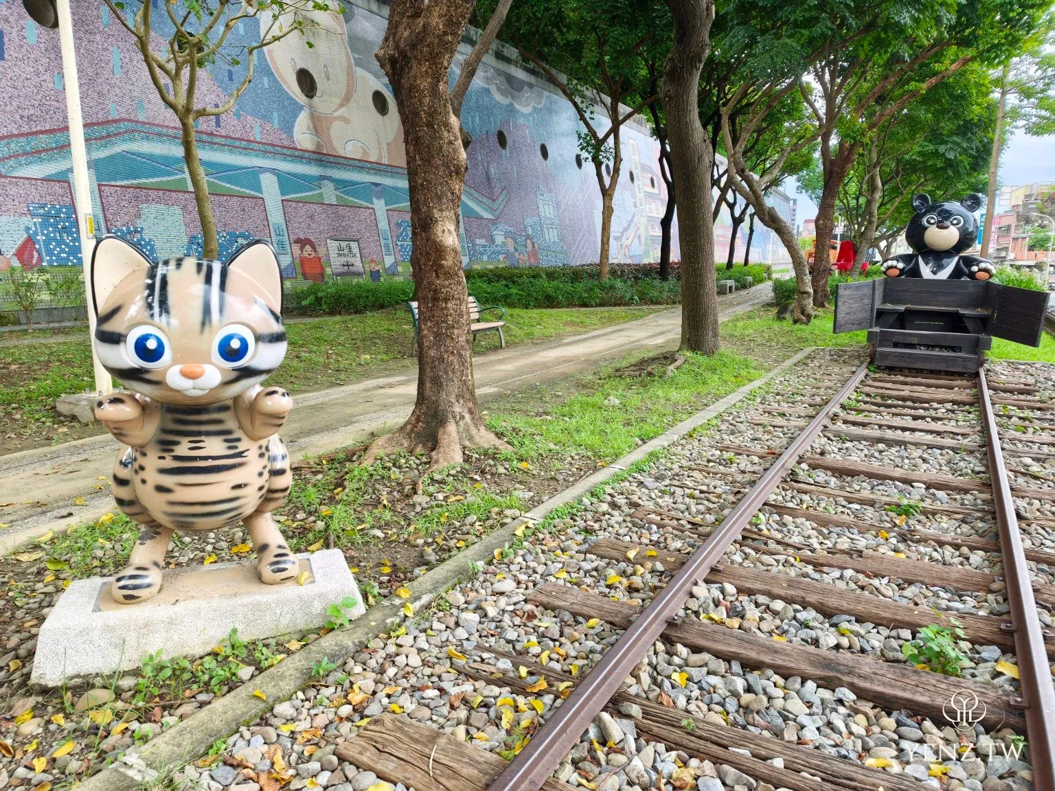 石虎與坐在礦車中的臺灣黑熊雕塑，位於鐵道地景公園。