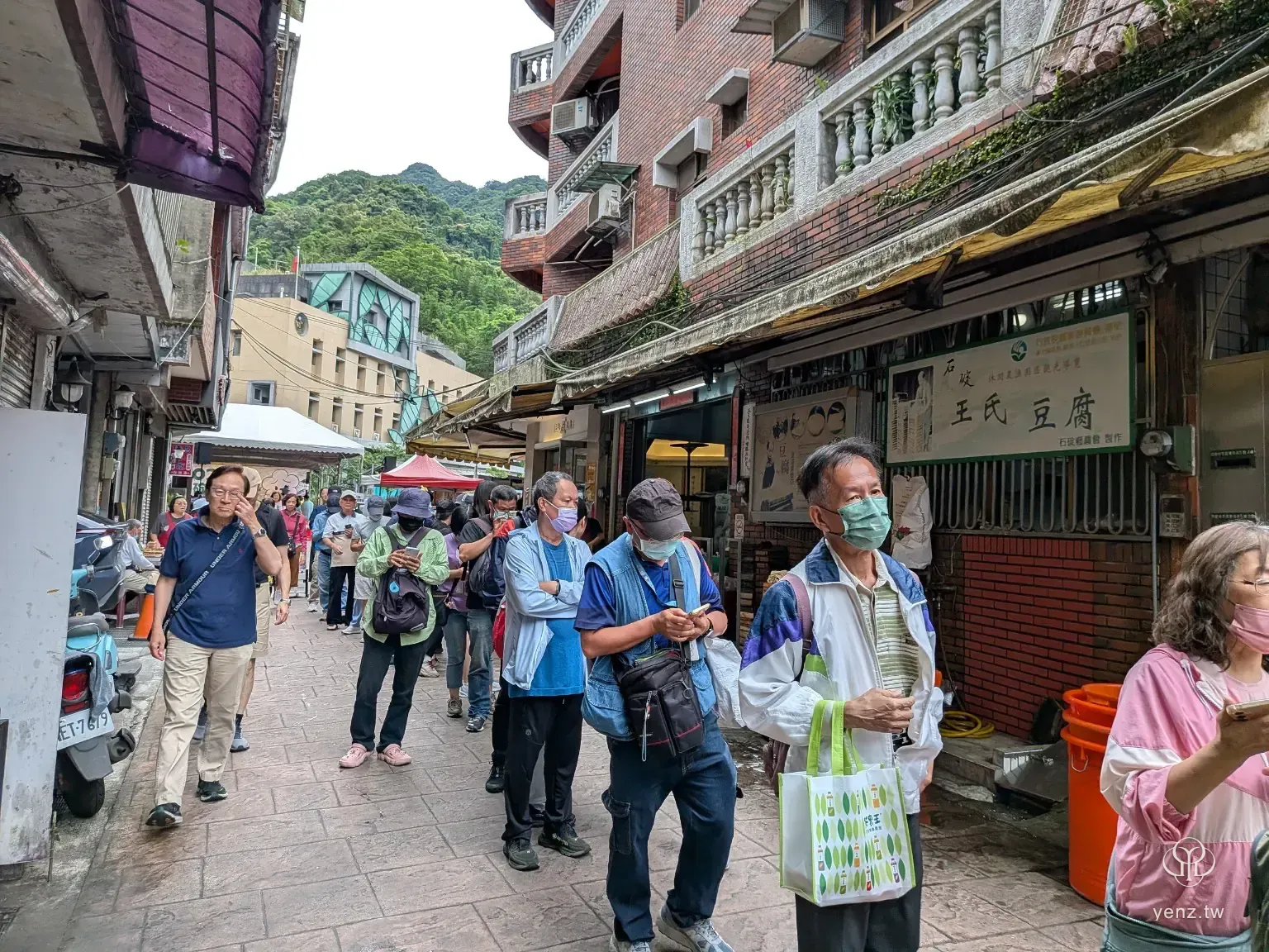 石碇老街人流與排隊動線，活動參與者沿著狹長街區移動。