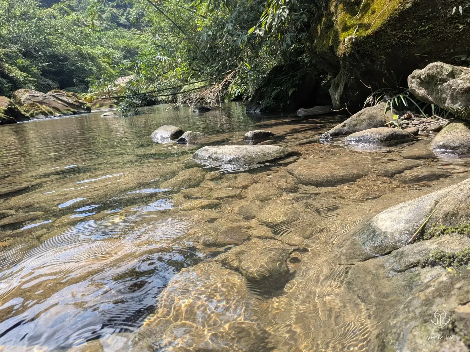可走下台階親近的烏塗溪水邊，清澈溪水流過石塊。