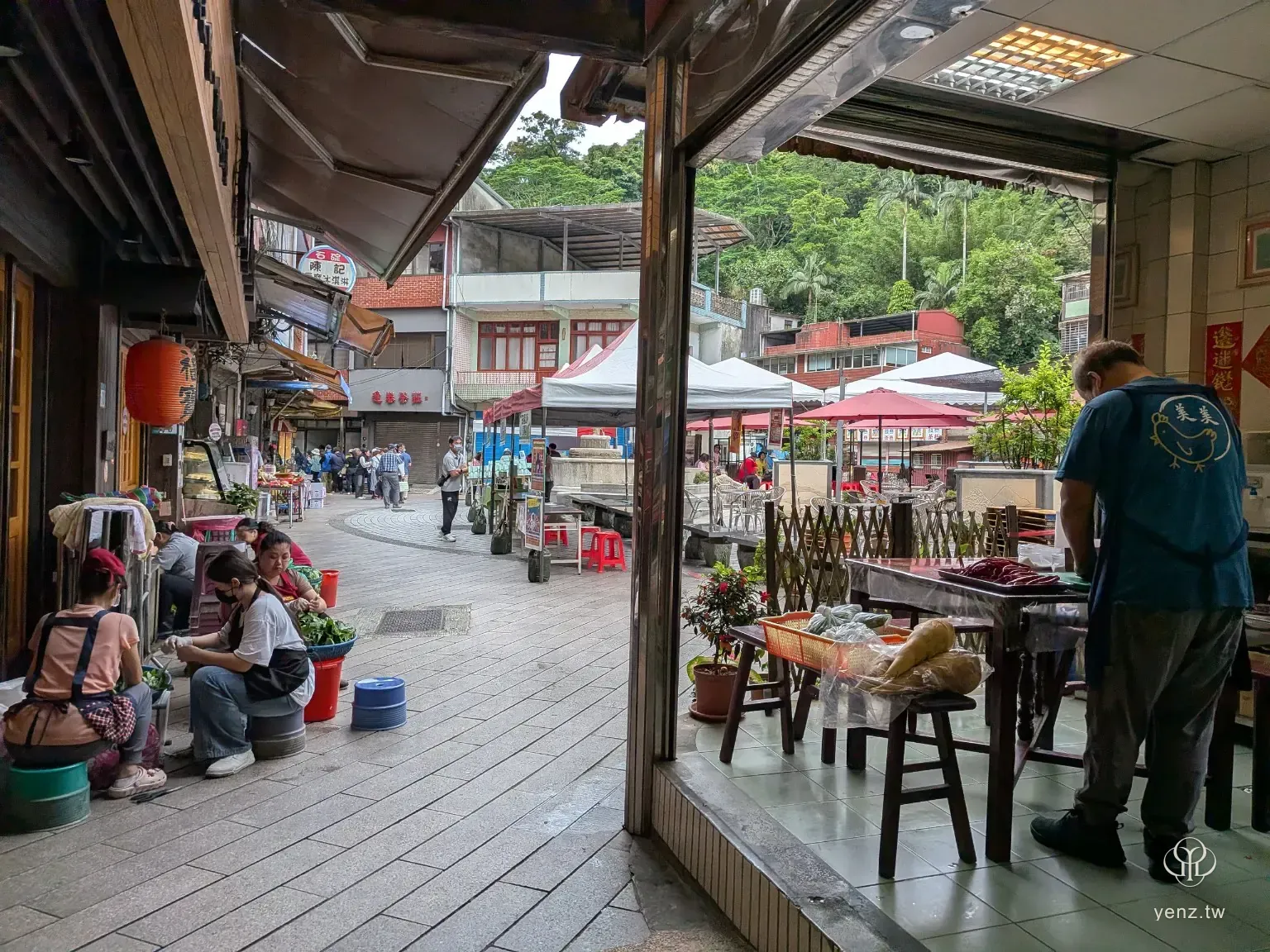 石碇老街生活場景與桐花祭活動帳篷同時出現，呈現活動嵌入老街日常。