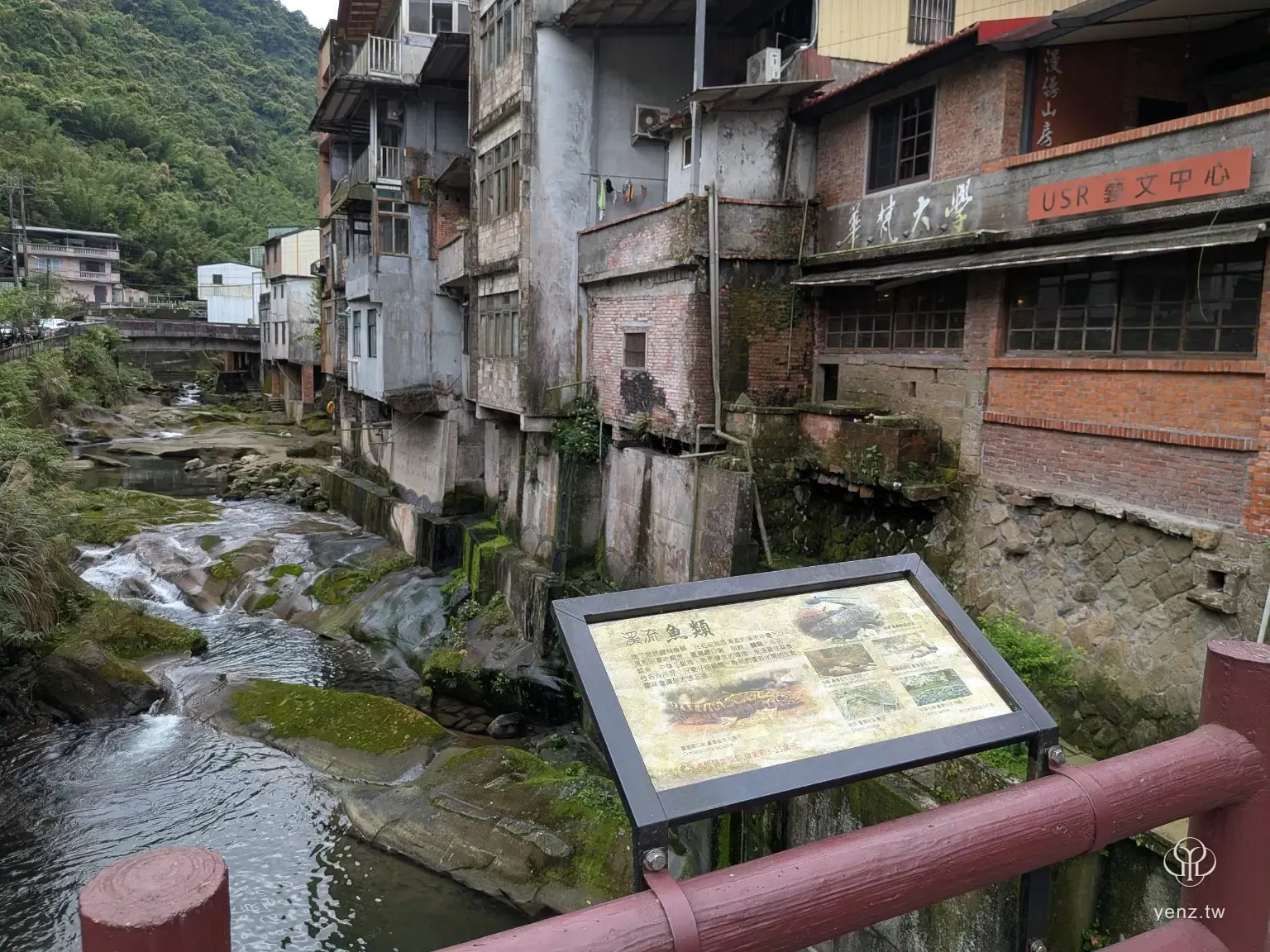 烏塗溪、溪畔老屋與水邊解說牌同框。