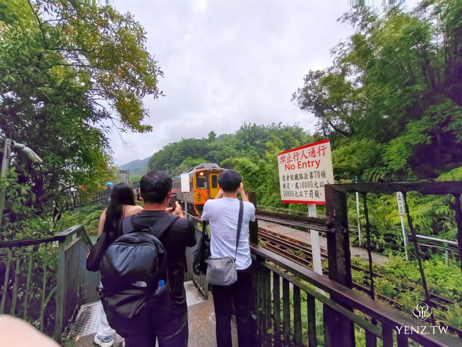列車駛近時，步道上的遊客紛紛停下腳步舉起手機拍攝。