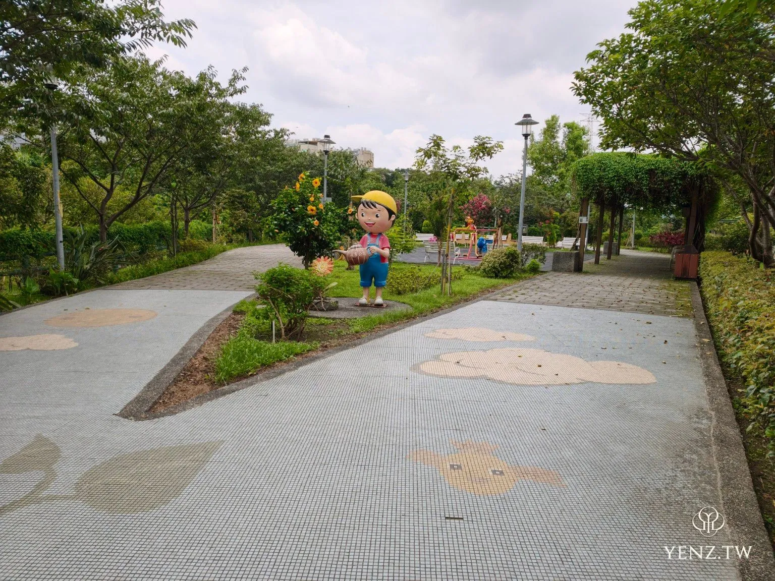 分岔步道、地面動物圖樣與澆花兒童雕塑。
