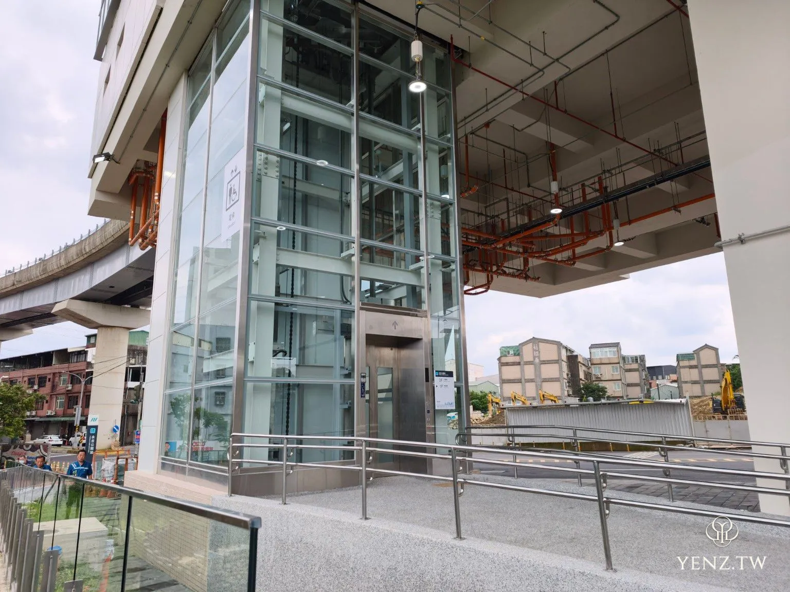 站體下方的無障礙電梯、坡道與仍在收尾的施工環境。