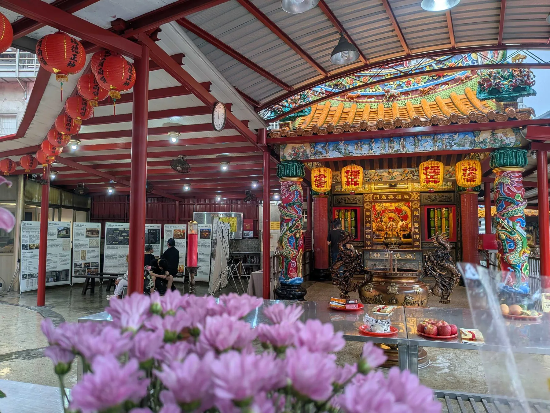 供桌上的菊花與展板群、福德宮正殿同框