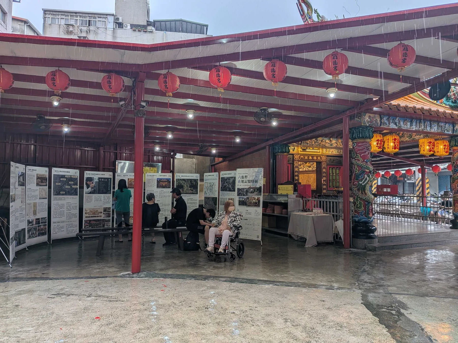 雨中的福德宮廟埕，紅燈籠下觀眾繼續看展