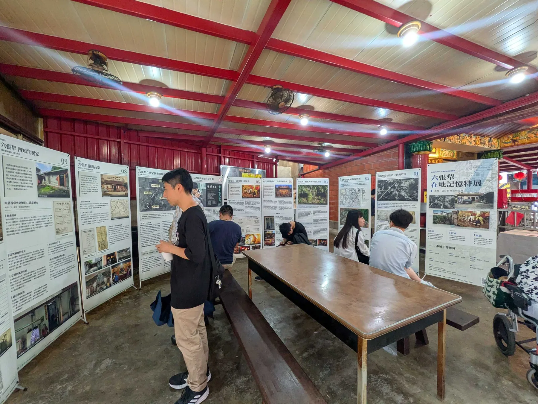 展場另一視角，觀眾在弧形排列的展板之間走動閱讀。