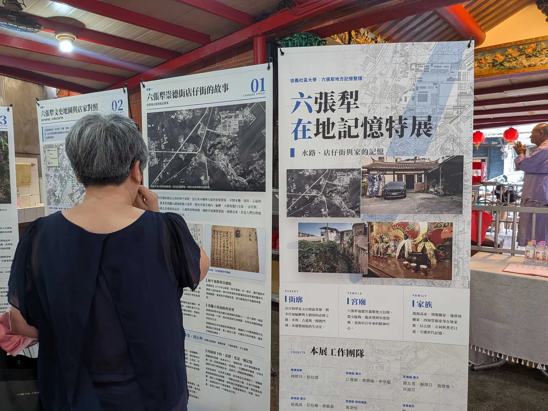 觀眾在街廓組展板前閱讀，展板上是民國 45 年航測影像與日治時期地契。