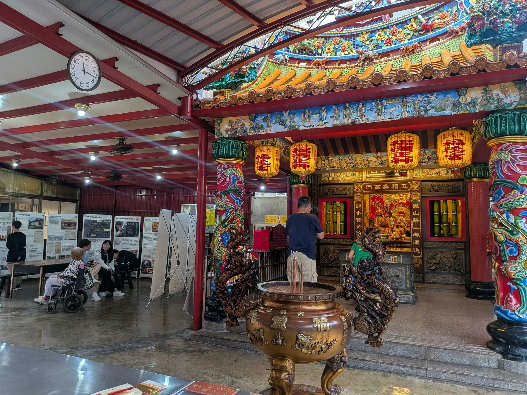 廟埕展場中，輪椅上的長者與家人一起看展。